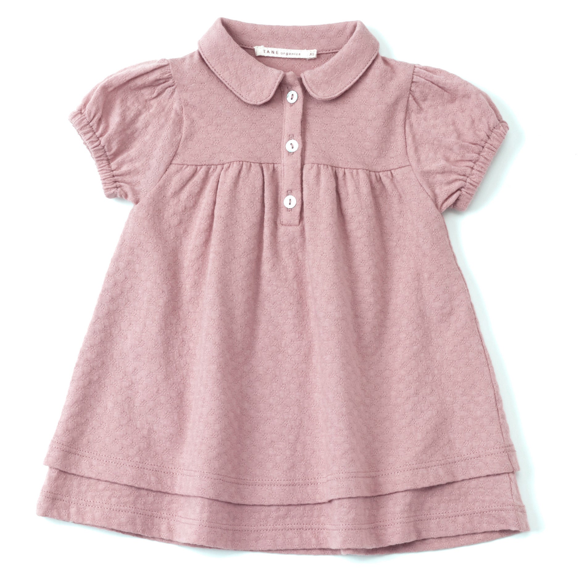 rose color pointelle double layered cap sleeved dress with peter pan collars and 3 natural shell buttons at the center front. Soft elastics at cuffs with delicate shirrings at the sleeves and bodice. 100% organic cotton pointelle knit.